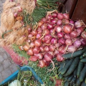 Oignons rouges au sol en vente avec concombre dans la rue de médina de Marrakech